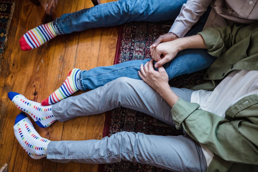 Same-sex couple holding hands during LGBTQIA+ relationship counseling